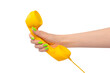 © Nikolay - Yellow handset in woman hand with green nails isolated on a white background.