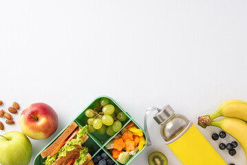 Capture essence of break snacks in educational process with top view photo showcasing lunch box and fruits, water bottle on white isolated backdrop, providing ample room for text or advertising.