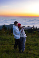 Wall Mural - couple a man and a woman together against the background of mountains, at sunrise, sunset, beautiful view,romantic date,travel family, love, lifestyle horizon, adventure, hiking, relationships outdoor