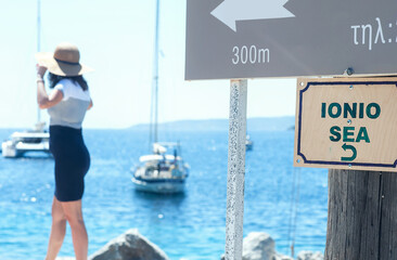 Wall Mural - Young woman dressed up for beach is enjoying her view at the Ionio Sea in Greece