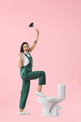 Sticker - Happy female plumber with plunger and toilet bowl on pink background