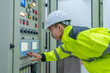 © reewungjunerr - Electrical engineer man checking voltage at the Power Distribution Cabinet in the control room,preventive maintenance Yearly,Thailand Electrician working at company