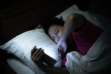 Asian Woman Playing Game On Smartphone In The Bed At Night,Thailand People,Addict Social Media