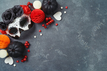 Day of the dead and Halloween holiday concept. Sugar skull mask and Mexican party decorations on dark background. Top view, flat lay