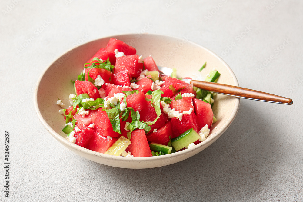 Bowl of tasty watermelon salad on light background