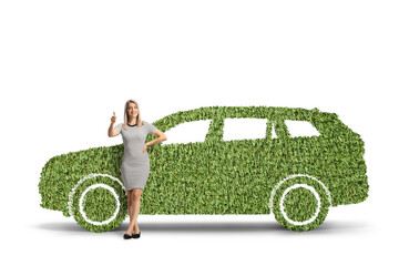 Poster - Full length portrait of a woman leaning on a car made of grass and gesturing thumbs up