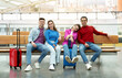 © Prostock-studio - Group Of Four Travelers Friends Sitting At Modern Airport