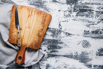 Wall Mural - Vintage wooden cutting board and wooden spoon and fork on a gray table. view from above. copyspace.