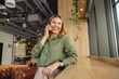 © Daria - Smiling woman manager is talking phone with client while standing on modern coworking background