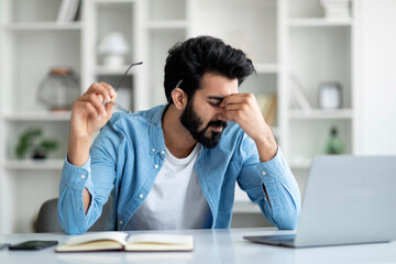 Wall Mural - Indian Freelancer Guy Suffering Eyes Fatigue While Working With Laptop At Home