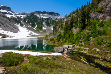 Sticker - Table Mountain, volcanic rock rising toward the sky and below, serene Upper Bagley Lake with a rock bridge through the river