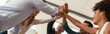 Leinwandbild Motiv We did it Business people giving each other high-five and smiling while working together in the modern office