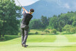 © buritora - ゴルフ場でアイアンショットをするゴルファーの男性