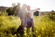 © Cavan Images - Asian Family of Three Standing in Field with Dog in San Diego