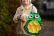 Little preschool kid girl holding selfmade traditional owl lanterns with candle for St. Martin procession. child happy about children and family parade in kindergarten. German tradition Martinsumzug