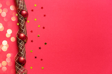 Canvas Print - Red Christmas background. Top view photo of red christmas tree balls toys, holiday ribbon, gold star ornaments with empty space on the right. Christmas Eve concept.