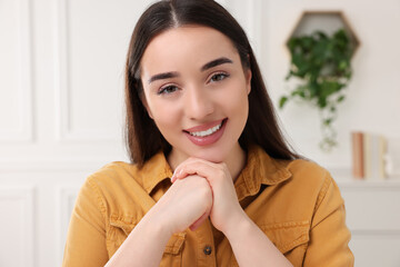 Wall Mural - Beautiful young woman having online video call at home, view from camera