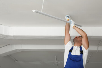 Poster - Electrician installing led linear lamp indoors, space for text. Ceiling light