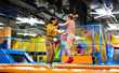 © Ievgen Skrypko - Pretty girl and her daughter kid jumping on colorful trampoline at playground park and smiling. Beautiful family during active entertaiments