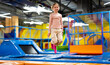 © Ievgen Skrypko - Pretty girl kid jumping on colorful trampoline at playground park and smiling. Beautiful preteen child during active entertaiments