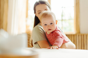 Wall Mural - Young smiling babysitter spending time with cute little baby