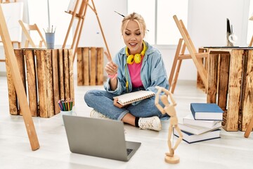 Sticker - Young caucasian woman artist having video call sitting on floor at art studio