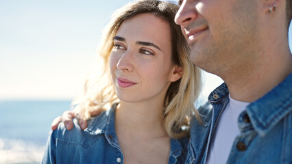 Poster - Man and woman couple smiling confident hugging each other at seaside