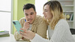 © Krakenimages.com - Man and woman students studying together using smartphone at library university
