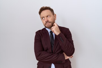 Poster - Middle age business man with beard wearing suit and tie with hand on chin thinking about question, pensive expression. smiling with thoughtful face. doubt concept.