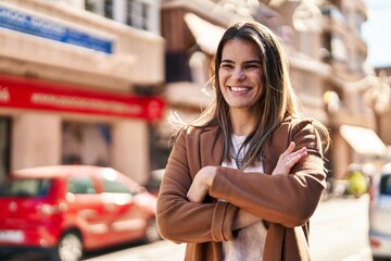 Canvas Print - Young beautiful hispanic woman standing with arms crossed gesture at street