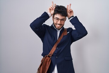 Wall Mural - Hispanic man with beard wearing business clothes posing funny and crazy with fingers on head as bunny ears, smiling cheerful