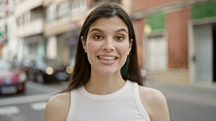 Wall Mural - Young beautiful hispanic woman smiling confident standing at street