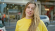 © Krakenimages.com - Young blonde woman standing with relaxed expression at street