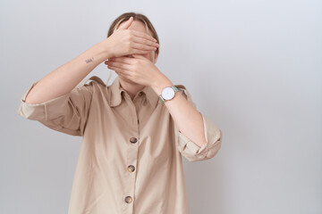 Poster - Young caucasian woman wearing casual shirt covering eyes and mouth with hands, surprised and shocked. hiding emotion