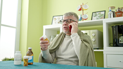 Poster - Middle age grey-haired man using smartphone having medical consultation talking by smartphone at home