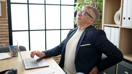 Canvas Print - Middle age grey-haired man business worker suffering for backache at office