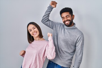 Young hispanic couple standing together dancing happy and cheerful, smiling moving casual and confident listening to music