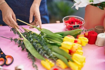 Wall Mural - Young blonde woman florist cutting stem at florist store