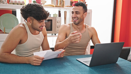 Wall Mural - Two men couple using laptop reading document at dinning room