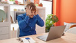 © Krakenimages.com - Young hispanic man using laptop stressed at dinning room