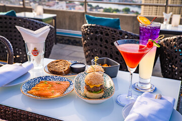 Wall Mural - Snack food and cocktail at a rooftop with the view on Chao Phraya river in Bangkok, Thailand