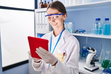 Sticker - Young caucasian woman scientist smiling confident using touchpad at laboratory