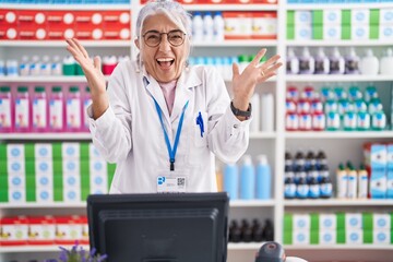 Poster - Middle age woman with tattoos working at pharmacy drugstore celebrating crazy and amazed for success with arms raised and open eyes screaming excited. winner concept