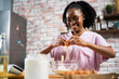 © JustLife - Young African woman in kitchen. Beautiful woman having fun while making dough..
