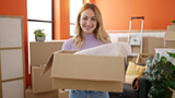 Fototapeta Sport - Young beautiful hispanic woman smiling confident holding package at new home