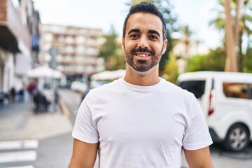 Wall Mural - Young hispanic man smiling confident standing at street