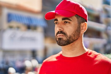 Sticker - Young hispanic man courier standing with relaxed expression at street