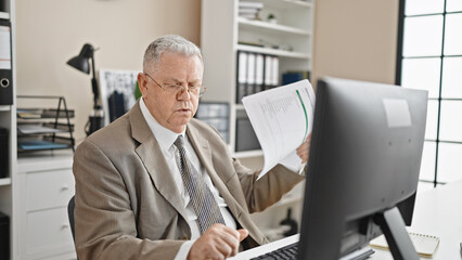 Sticker - Middle age grey-haired man business worker using computer using documents as a handfan at office