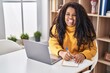 © Krakenimages.com - African american woman using laptop writing on notebook at home