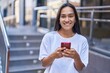 © Krakenimages.com - Young beautiful hispanic woman smiling confident using smartphone at street